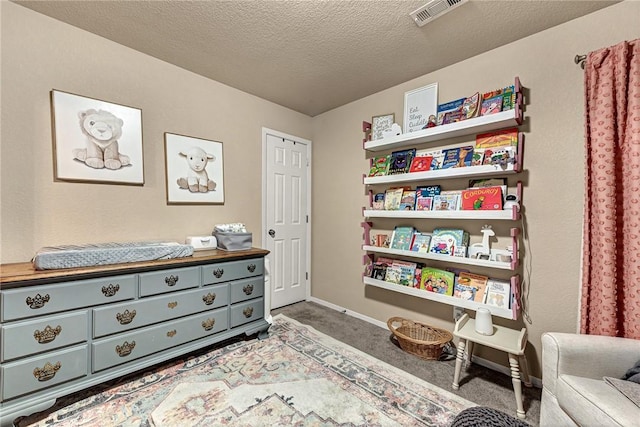 interior space featuring carpet floors, baseboards, visible vents, and a textured ceiling