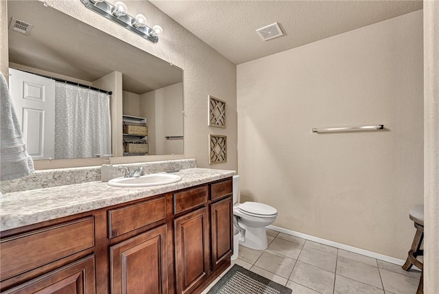 bathroom featuring toilet, vanity, visible vents, and tile patterned floors