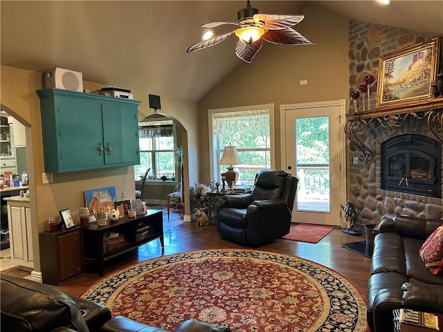 living area featuring arched walkways, vaulted ceiling, and a healthy amount of sunlight