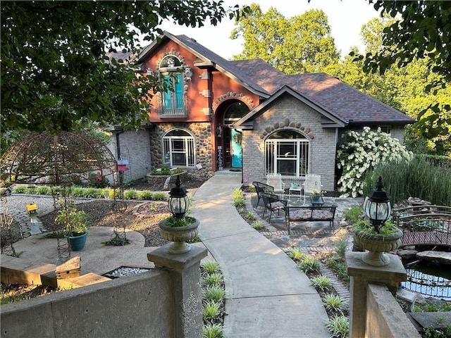 view of front of property featuring stone siding and a patio