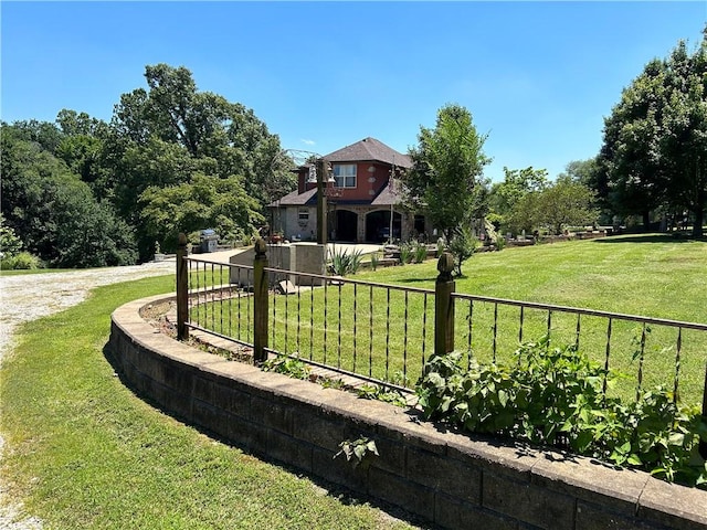 view of yard featuring driveway and fence