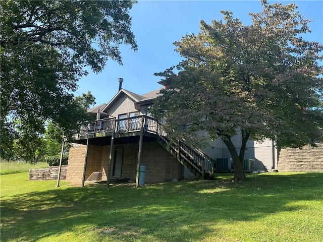 back of house featuring a lawn, a deck, and stairs