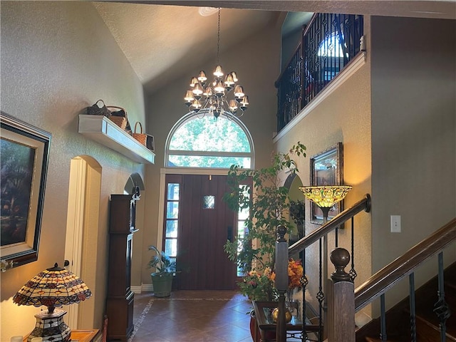 tiled entryway featuring stairs, high vaulted ceiling, and a chandelier