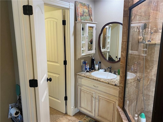 bathroom with a stall shower, vanity, and tile patterned floors