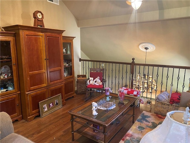 living area featuring visible vents, vaulted ceiling, and wood finished floors