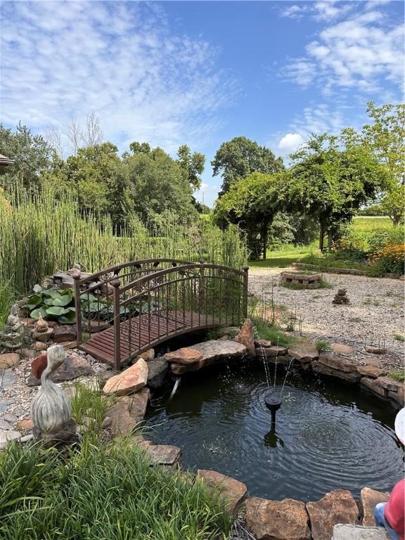 view of community featuring a garden pond