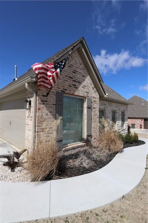 view of home's exterior with brick siding and a garage