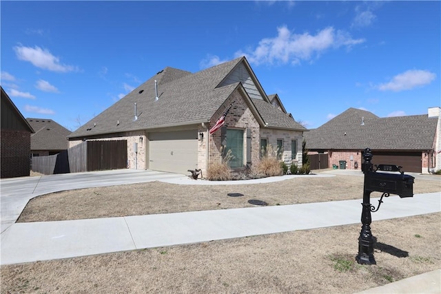 view of front of property featuring brick siding, driveway, roof with shingles, and fence