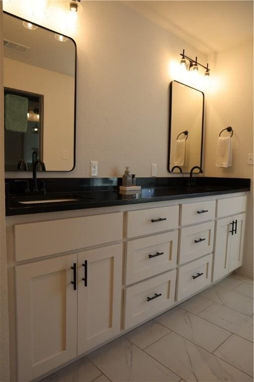 bathroom with double vanity, visible vents, marble finish floor, and a sink