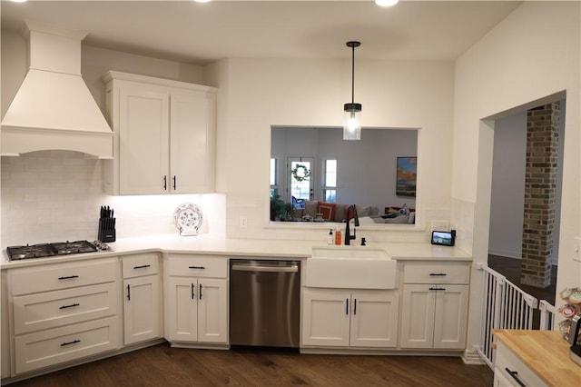 kitchen with premium range hood, dark wood-style flooring, appliances with stainless steel finishes, white cabinets, and a sink