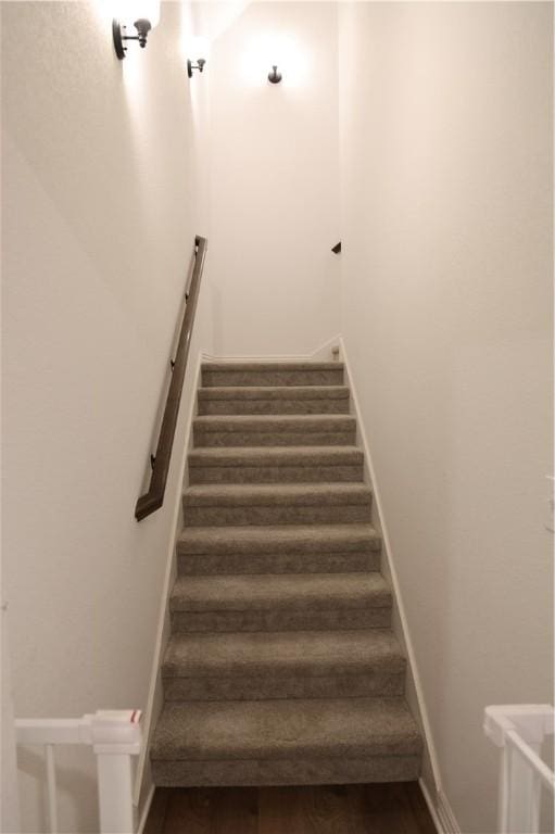 staircase with wood finished floors and baseboards