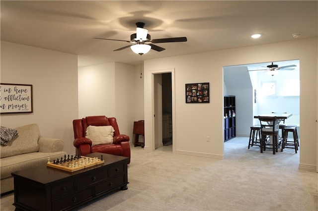 living area featuring ceiling fan, recessed lighting, baseboards, and light carpet