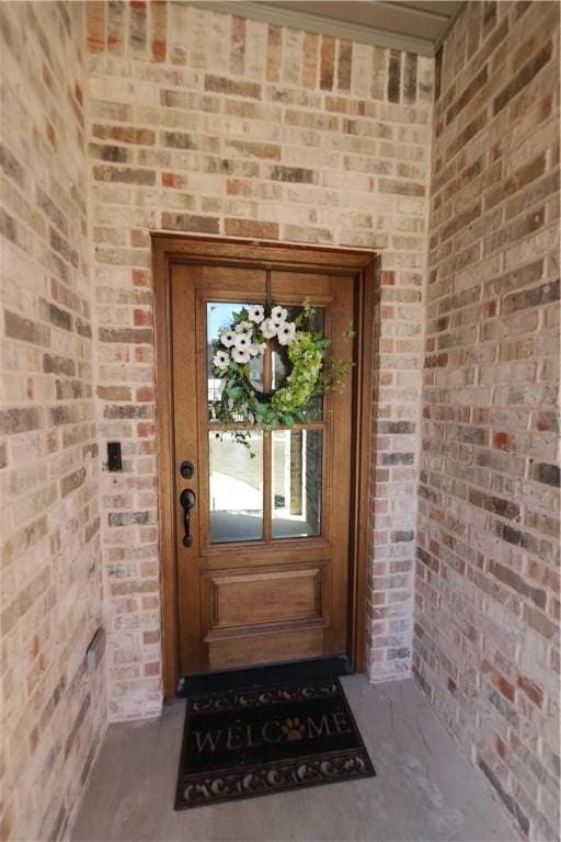 view of exterior entry with brick siding