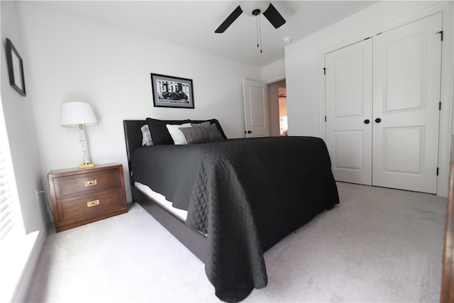 bedroom featuring a closet, light colored carpet, and ceiling fan