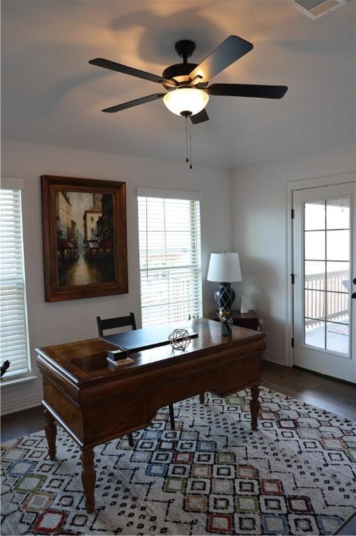 office area with a ceiling fan and baseboards