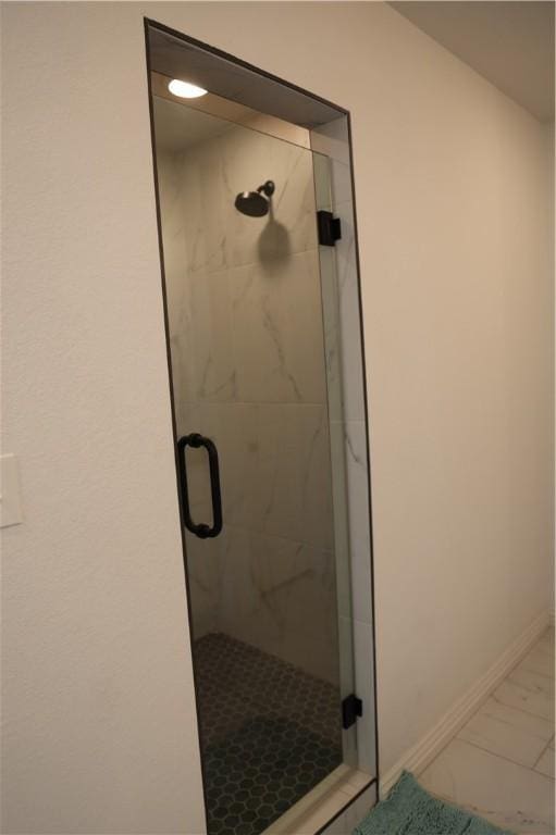 full bathroom featuring baseboards and a stall shower