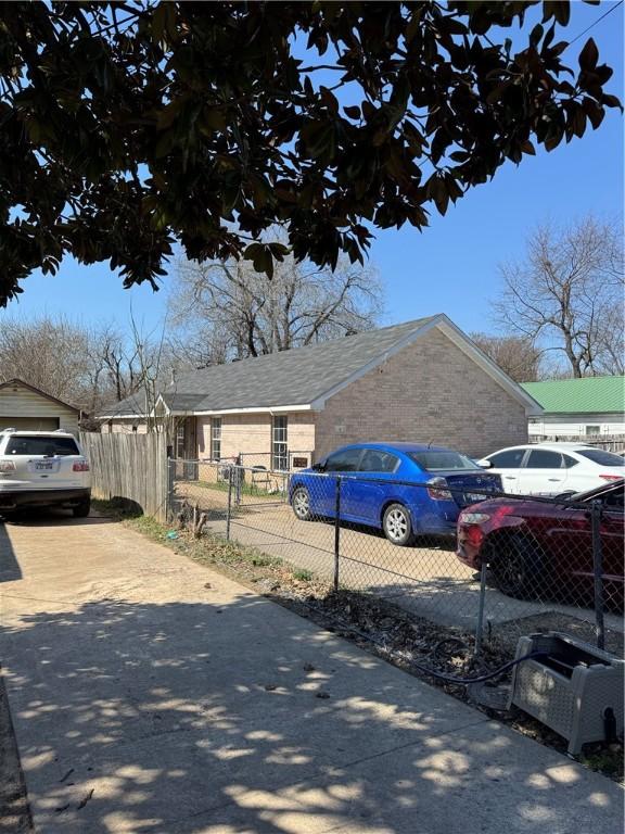 exterior space featuring a fenced front yard, brick siding, and driveway