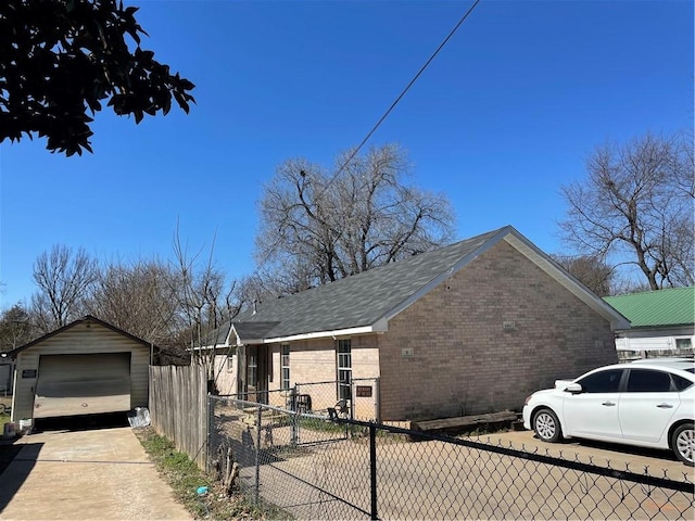 view of property exterior featuring an outbuilding, a detached garage, fence, concrete driveway, and brick siding