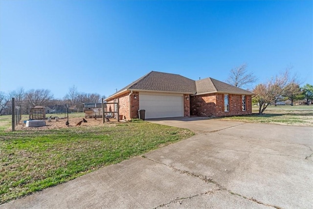 view of home's exterior with a garage, brick siding, driveway, and a yard