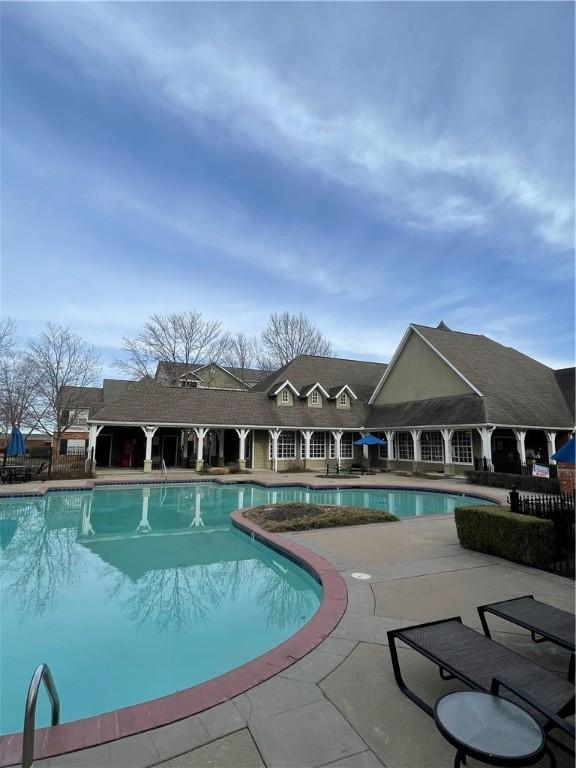 pool with a patio and fence