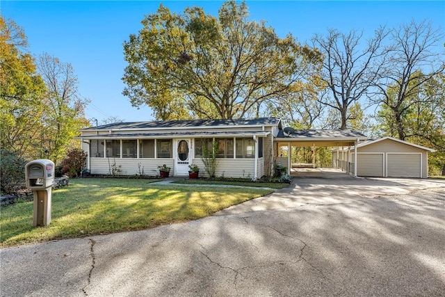 view of front of home featuring a carport, a garage, an outdoor structure, and a front lawn