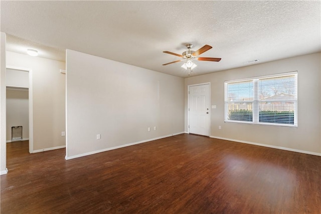 spare room featuring a ceiling fan, wood finished floors, baseboards, and a textured ceiling