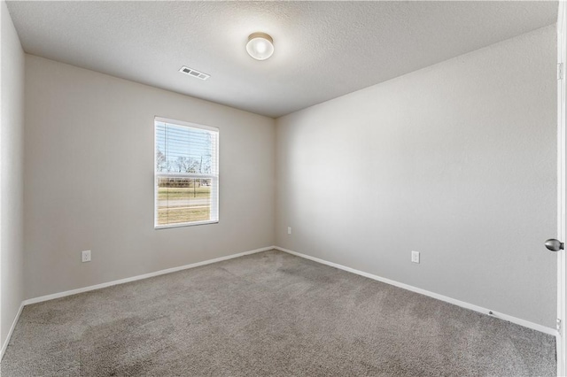 carpeted empty room featuring visible vents, baseboards, and a textured ceiling