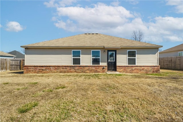 back of house with a yard, fence private yard, and brick siding