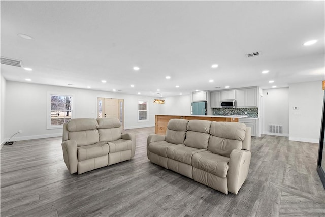 living room featuring visible vents, recessed lighting, and light wood-type flooring