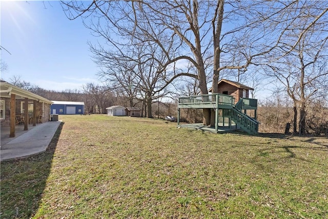 view of yard featuring stairs, an outdoor structure, and a wooden deck