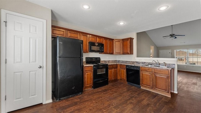 kitchen with black appliances, brown cabinetry, a peninsula, and a sink