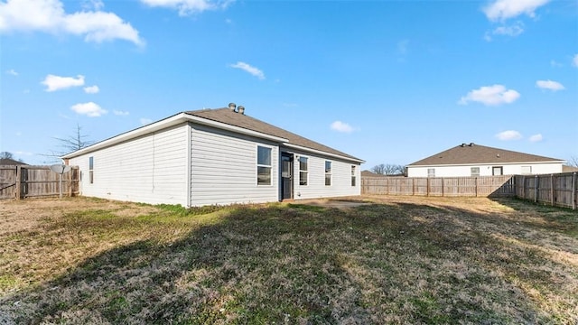 back of property featuring a lawn and a fenced backyard