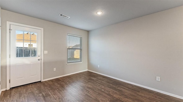 doorway to outside with visible vents, baseboards, and dark wood finished floors