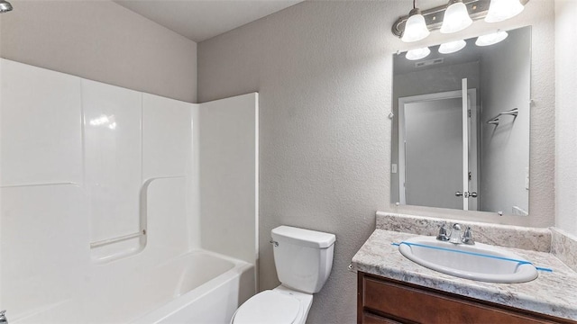 bathroom featuring visible vents, toilet, vanity, and a textured wall