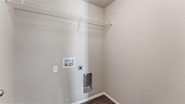 clothes washing area with electric dryer hookup, dark wood-type flooring, washer hookup, baseboards, and laundry area