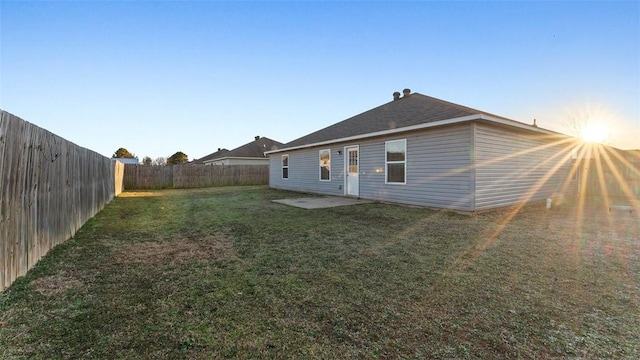 back of house with a lawn and a fenced backyard