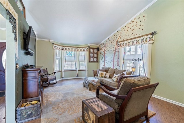 living room with plenty of natural light, crown molding, and wood finished floors