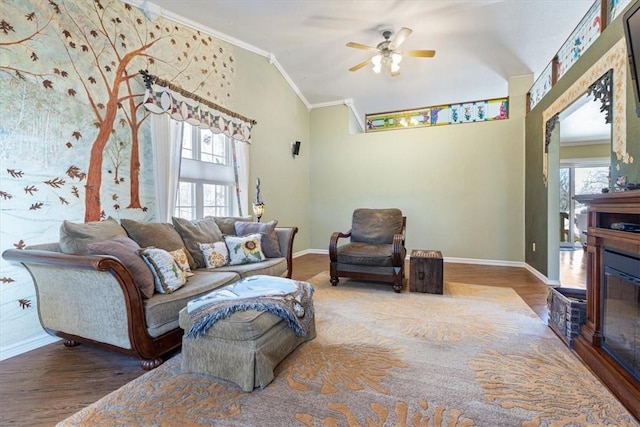 living room with a glass covered fireplace, a healthy amount of sunlight, crown molding, and wood finished floors