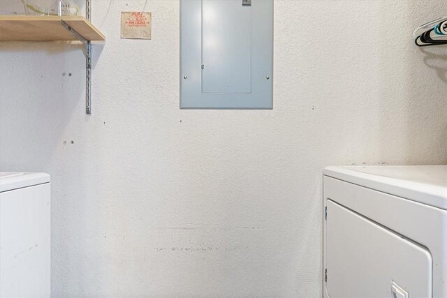 laundry room with laundry area, electric panel, and washing machine and clothes dryer