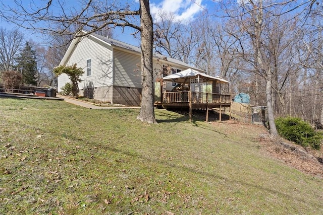 rear view of property featuring a yard and a wooden deck