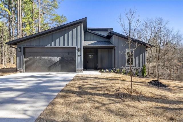 mid-century home featuring an attached garage, board and batten siding, driveway, and a shingled roof