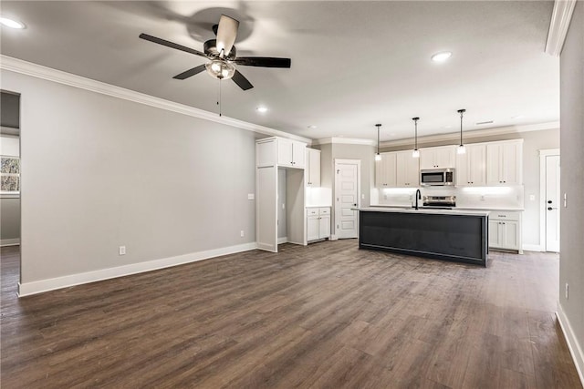 kitchen with dark wood-style floors, white cabinetry, stainless steel appliances, crown molding, and baseboards