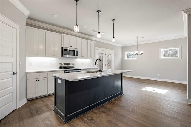 kitchen featuring dark wood finished floors, a sink, stainless steel appliances, crown molding, and backsplash