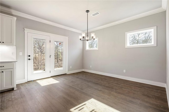 unfurnished dining area featuring dark wood finished floors, visible vents, a healthy amount of sunlight, and ornamental molding