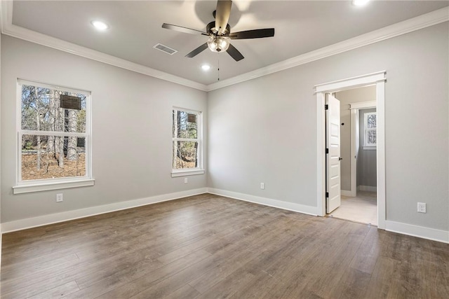 spare room featuring visible vents, baseboards, ceiling fan, ornamental molding, and wood finished floors