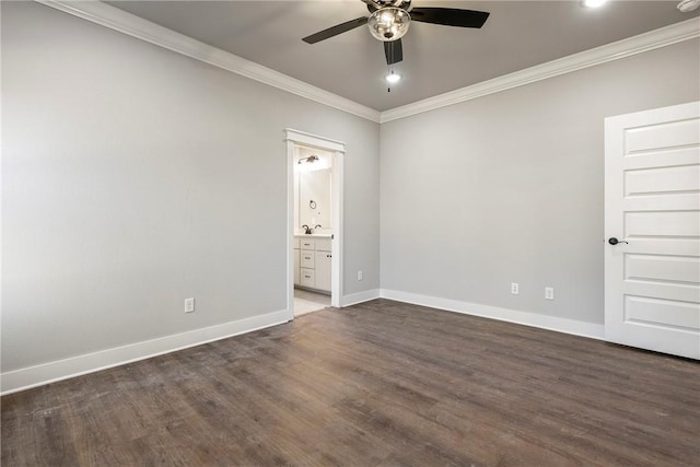 empty room with dark wood-style floors, baseboards, and ornamental molding