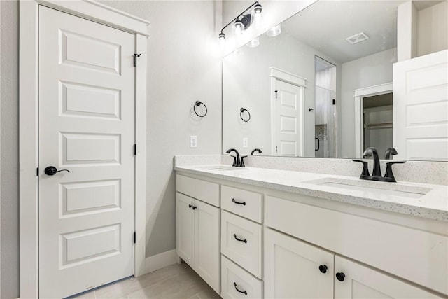 bathroom featuring double vanity, visible vents, and a sink