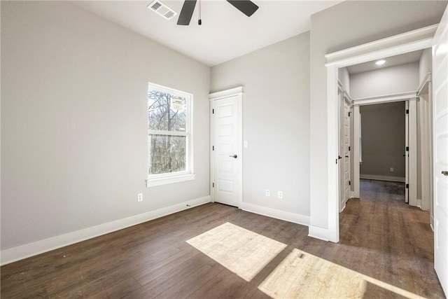 unfurnished bedroom featuring a ceiling fan, wood finished floors, baseboards, and visible vents