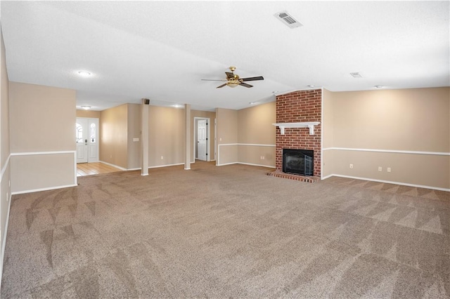 unfurnished living room featuring visible vents, a ceiling fan, carpet floors, a brick fireplace, and vaulted ceiling