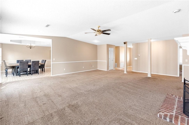 unfurnished living room with carpet, visible vents, baseboards, vaulted ceiling, and ceiling fan with notable chandelier